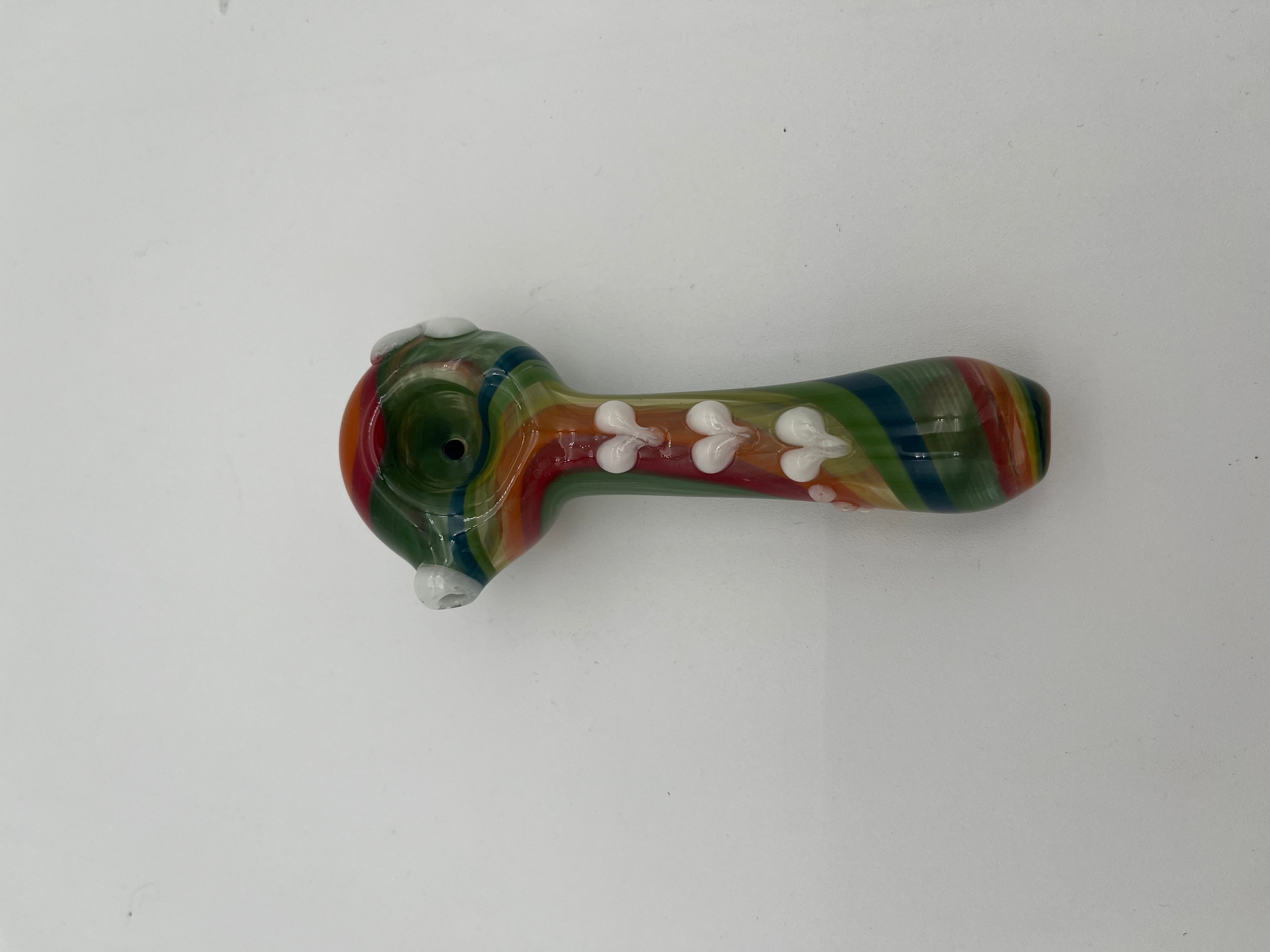 Rainbow glass pipe with white heart detailing on it displayed on a white background. Made by Kristi Conant.