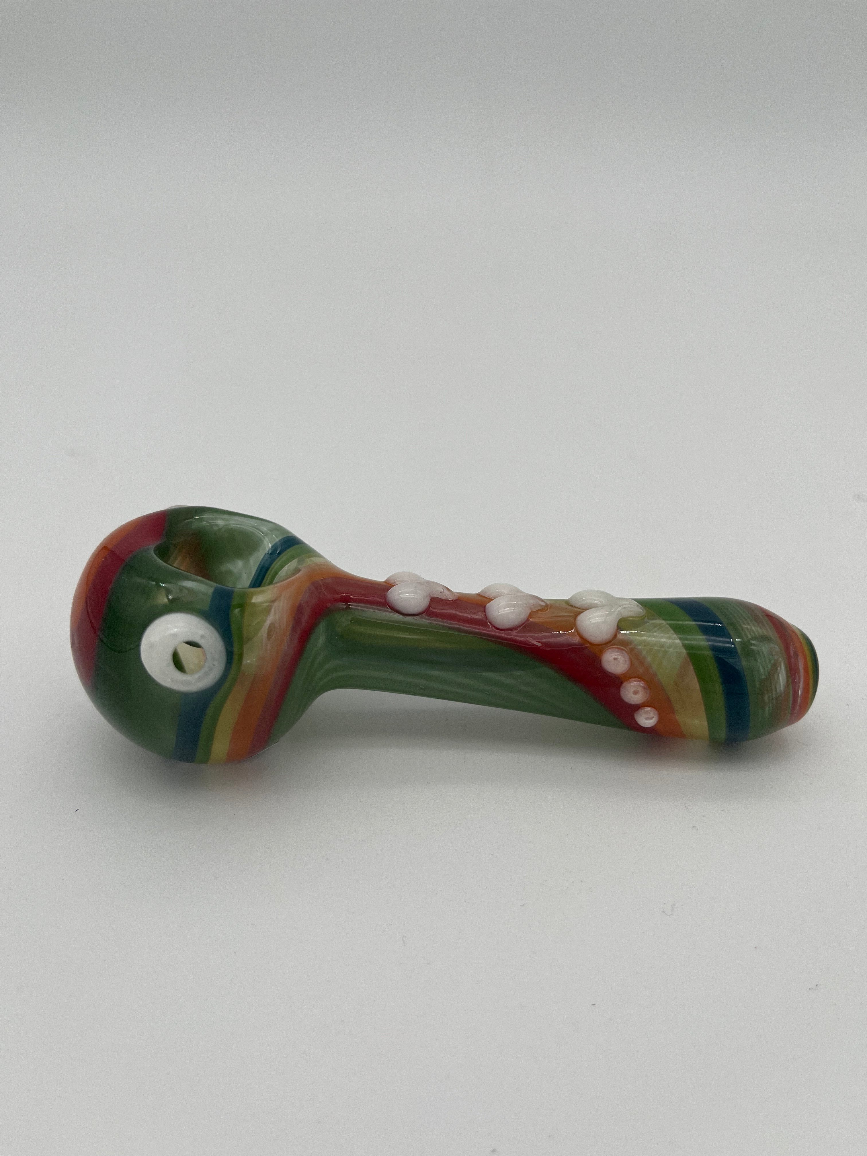Rainbow glass pipe with white heart detailing on it displayed on a white background. Made by Kristi Conant.