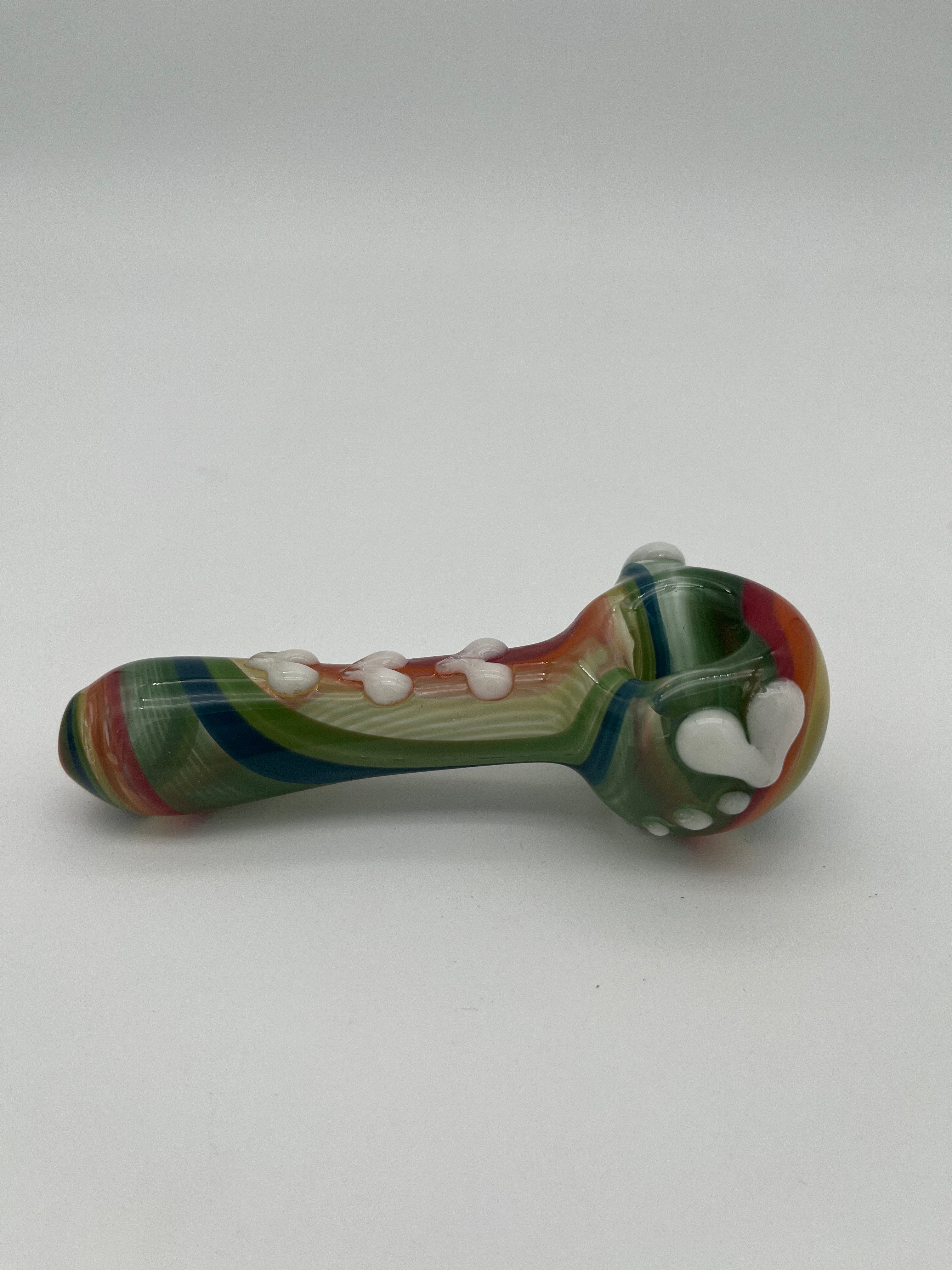 Rainbow glass pipe with white heart detailing on it displayed on a white background. Made by Kristi Conant.