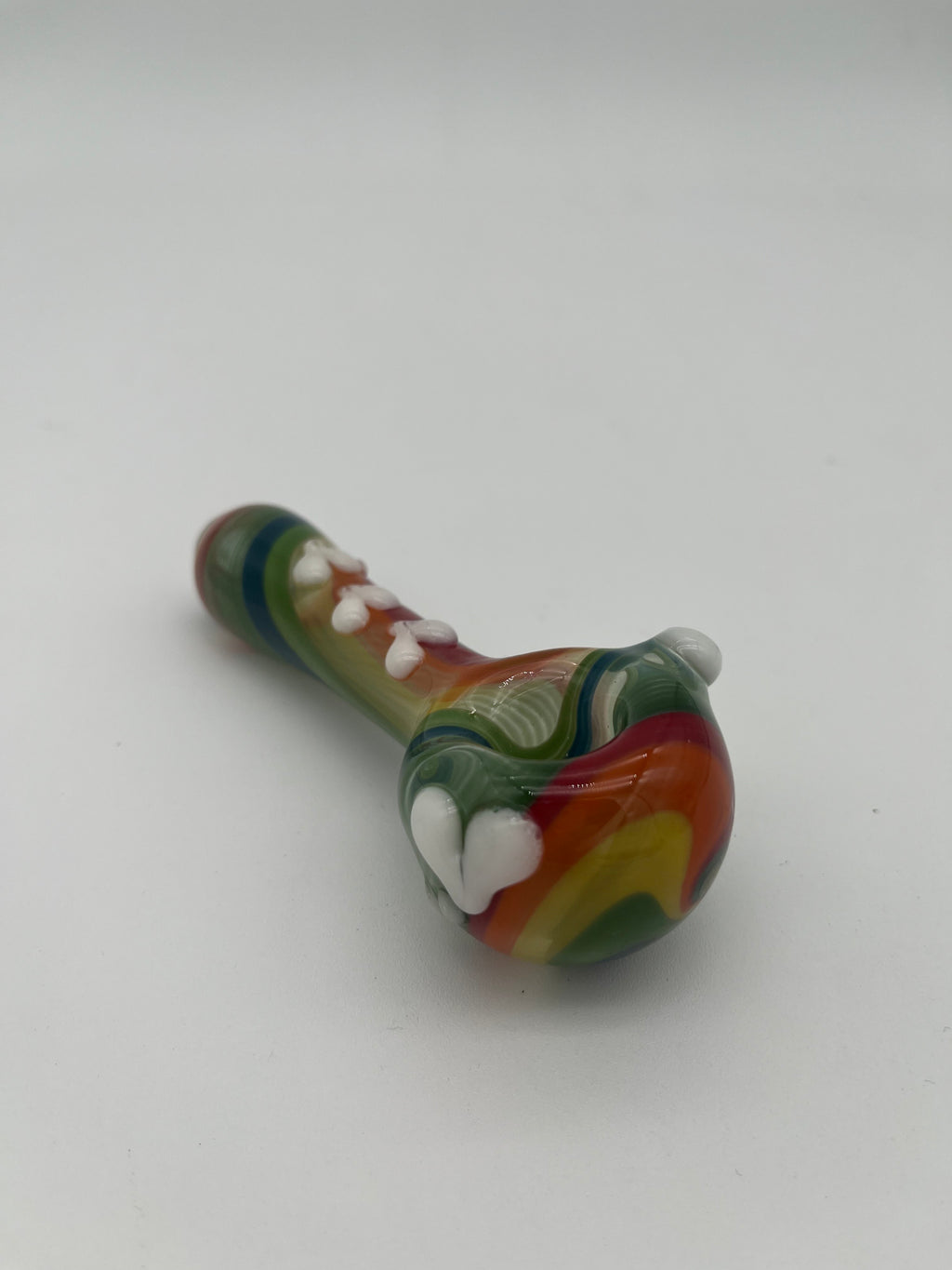 Rainbow glass pipe with white heart detailing on it displayed on a white background. Made by Kristi Conant.