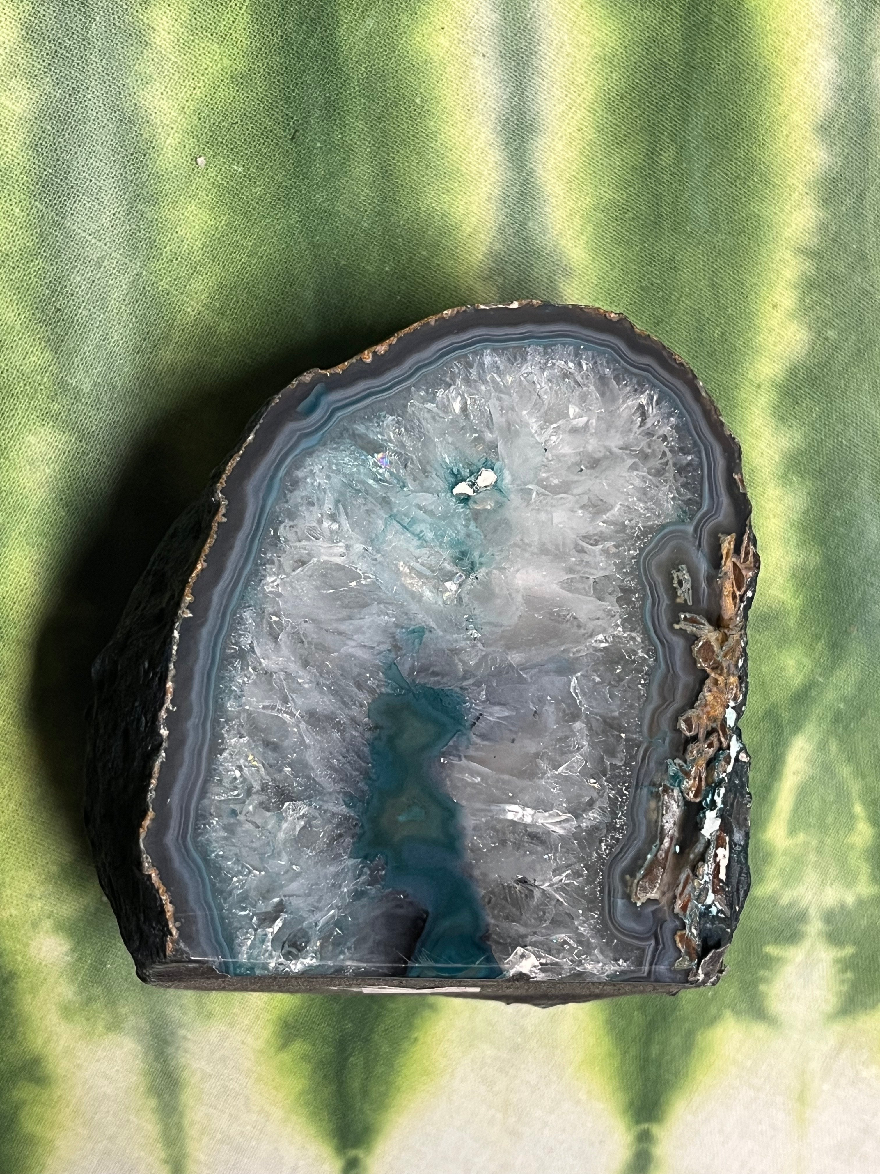 Geode slice with crystal formation on a green fabric background