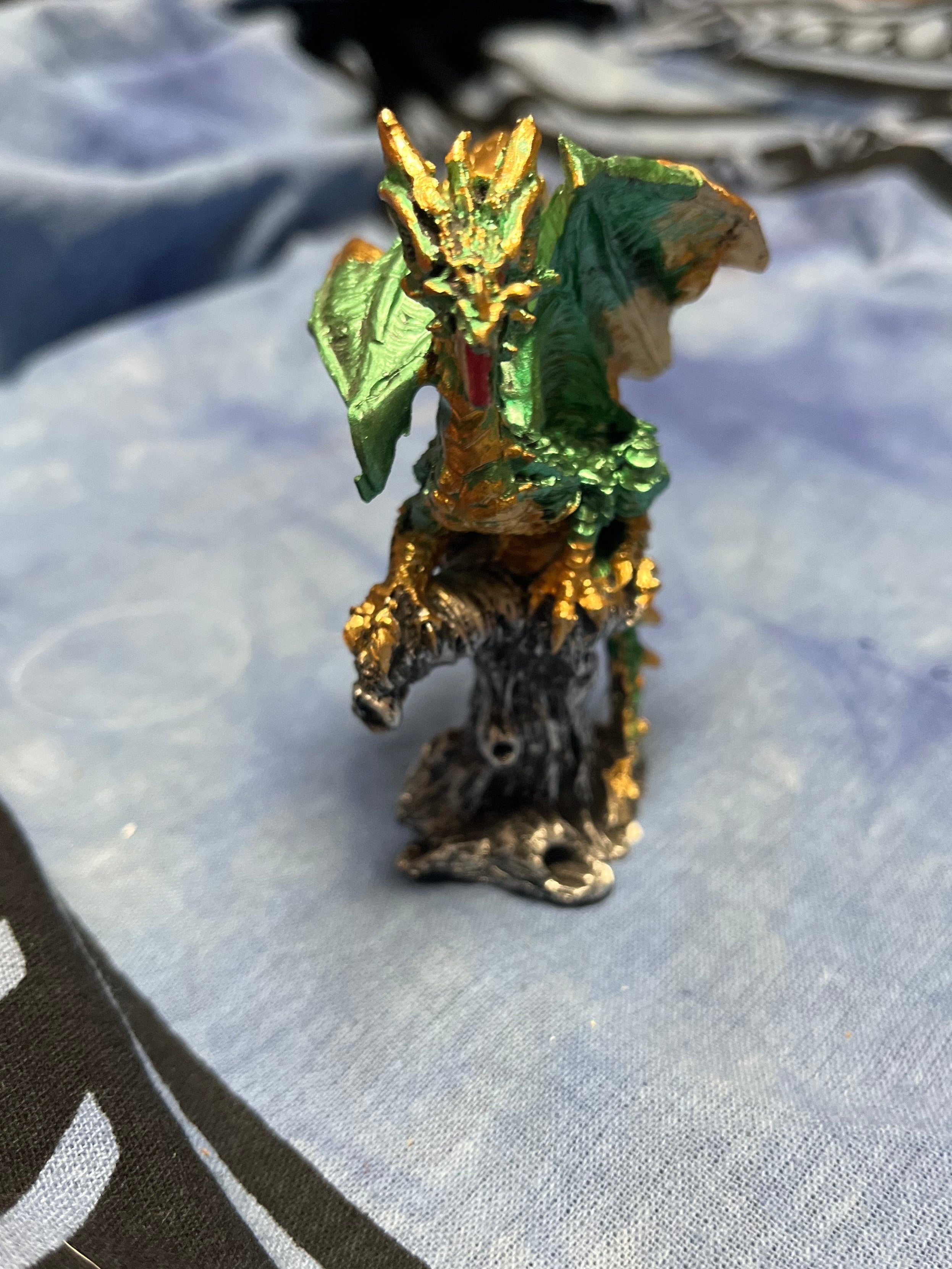 Small figurine of a dragon on a textured fabric background